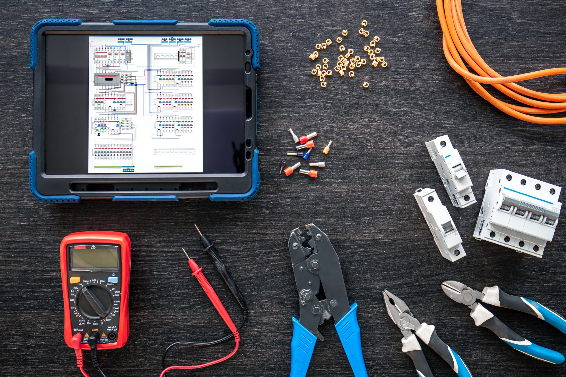 Electrical wiring diagram on tablet with tools.